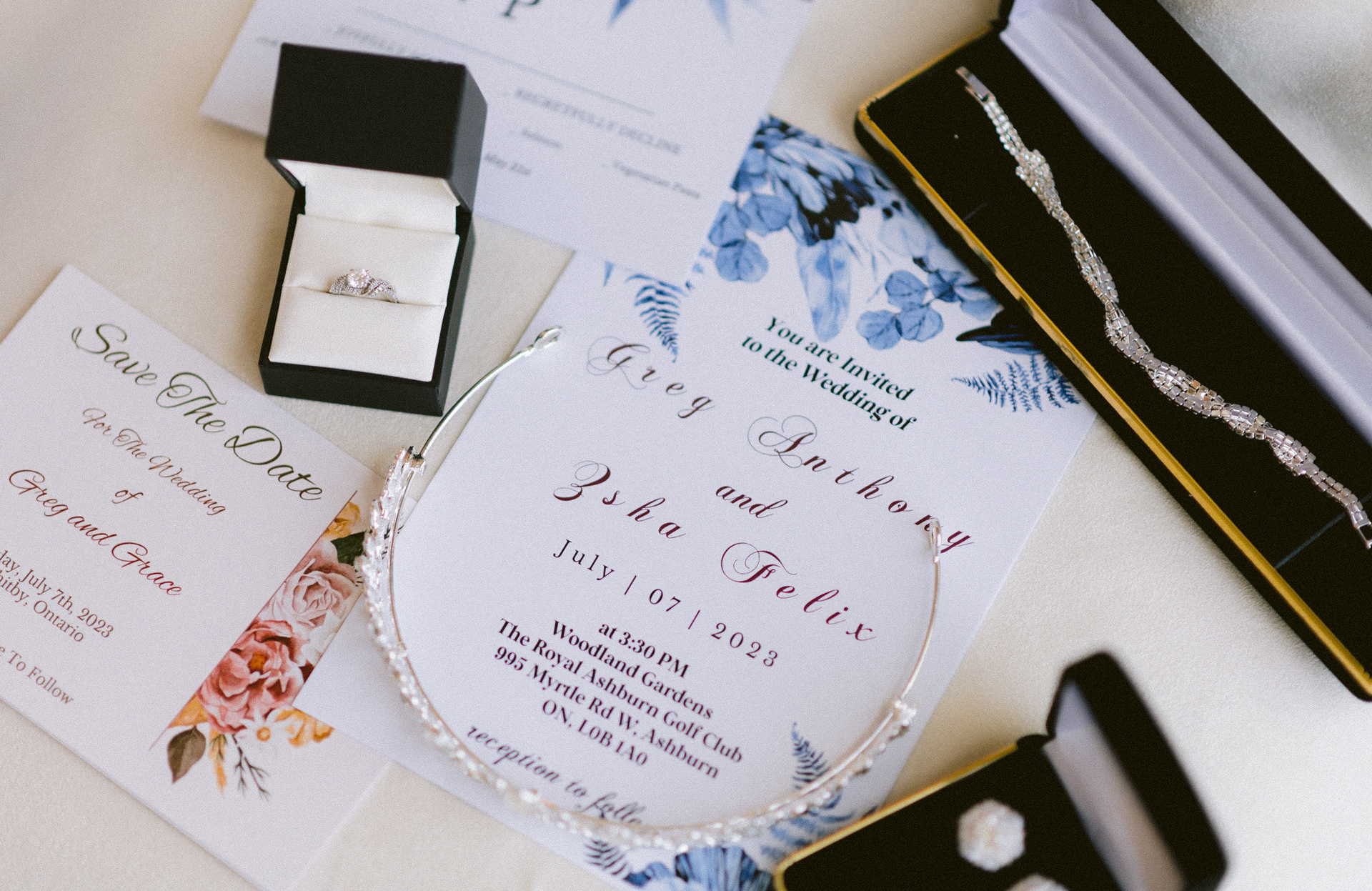 Elegant wedding invitations surrounded by bridal accessories, including a sparkling tiara, a jewelry box with rings, and a luxurious satin glove.