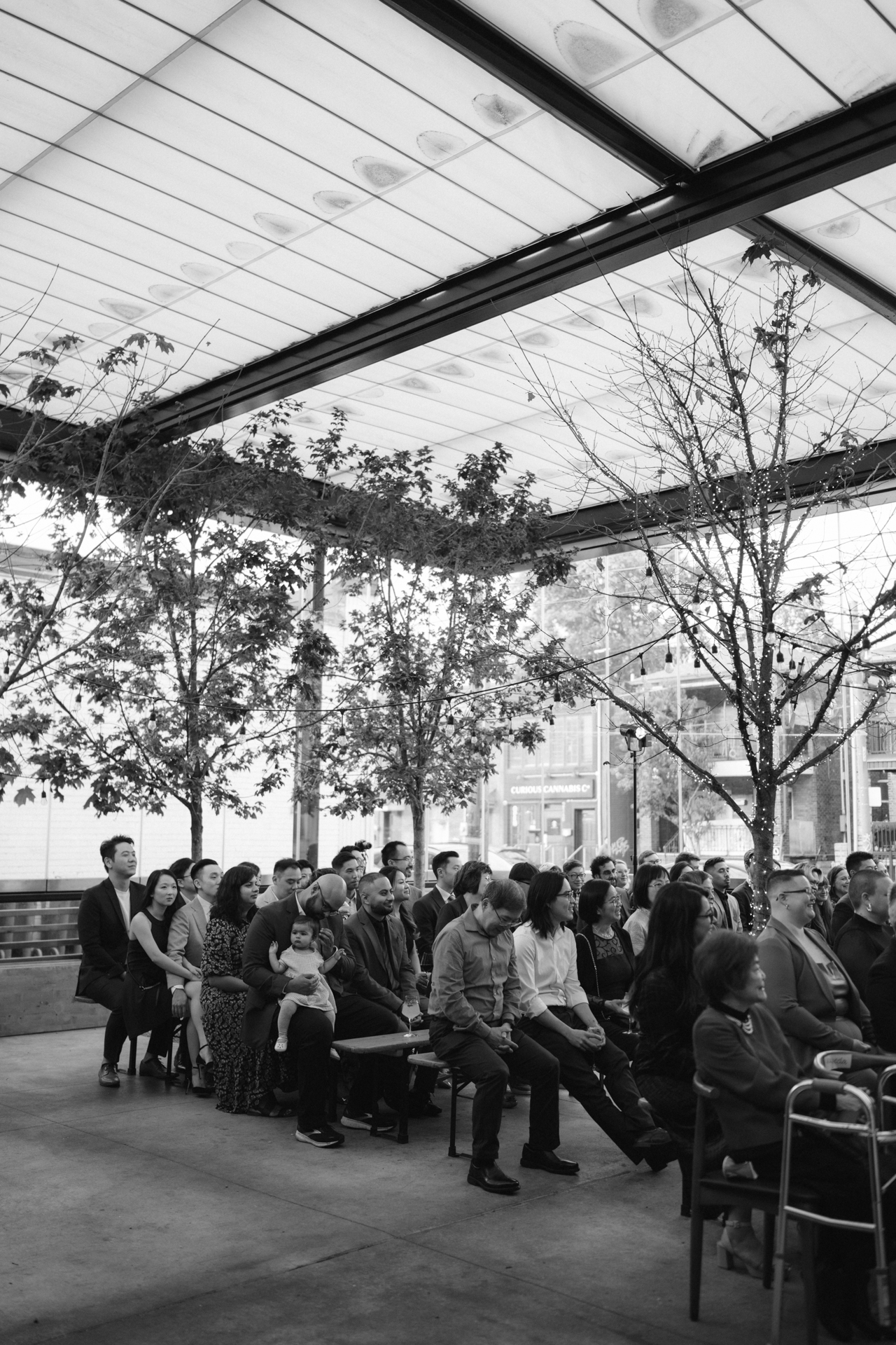 Guests seating in multiple rows while waiting for bride to walk down the aisle.