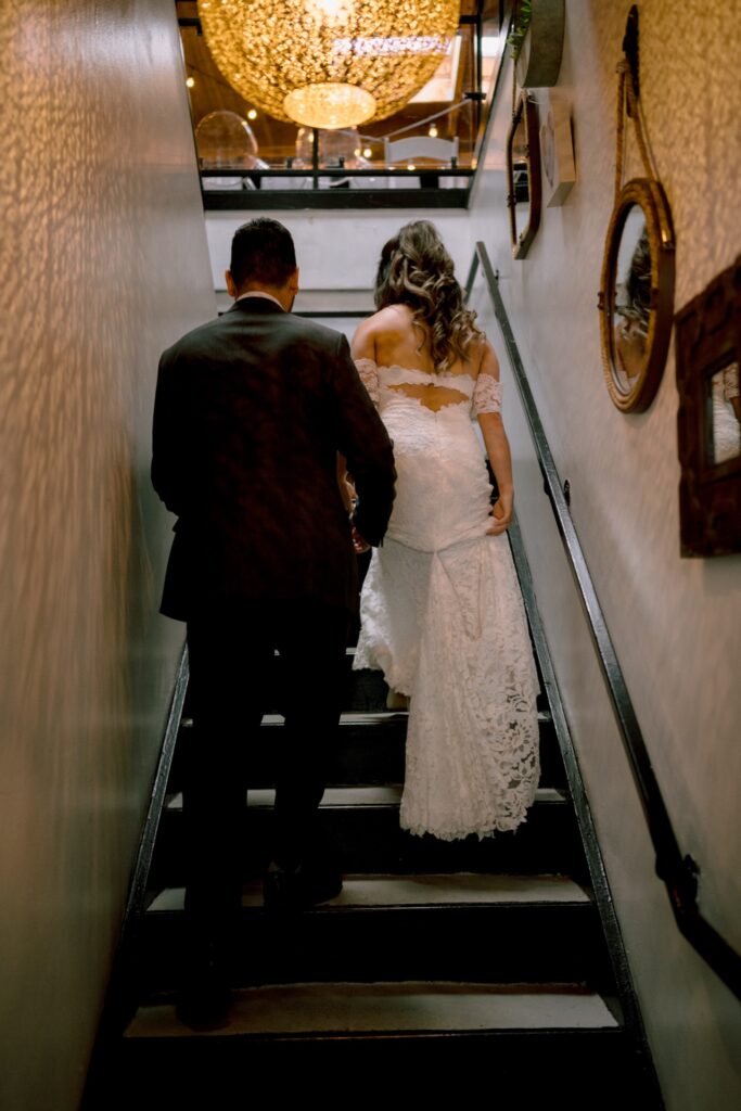 Groom holding bride have their grand entrance at Twist Gallery.
