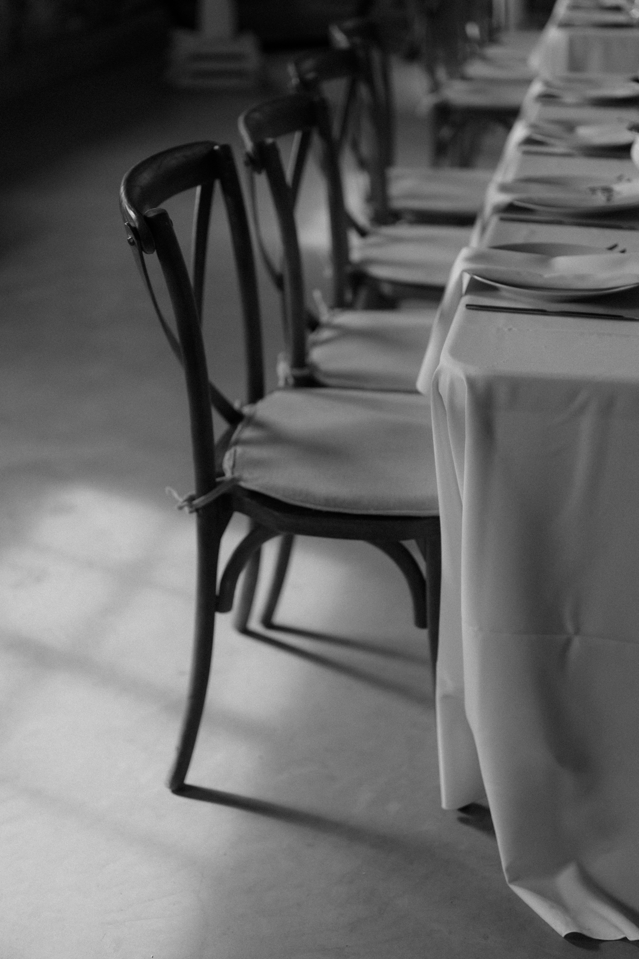 An elegantly set banquet table in a rustic venue.