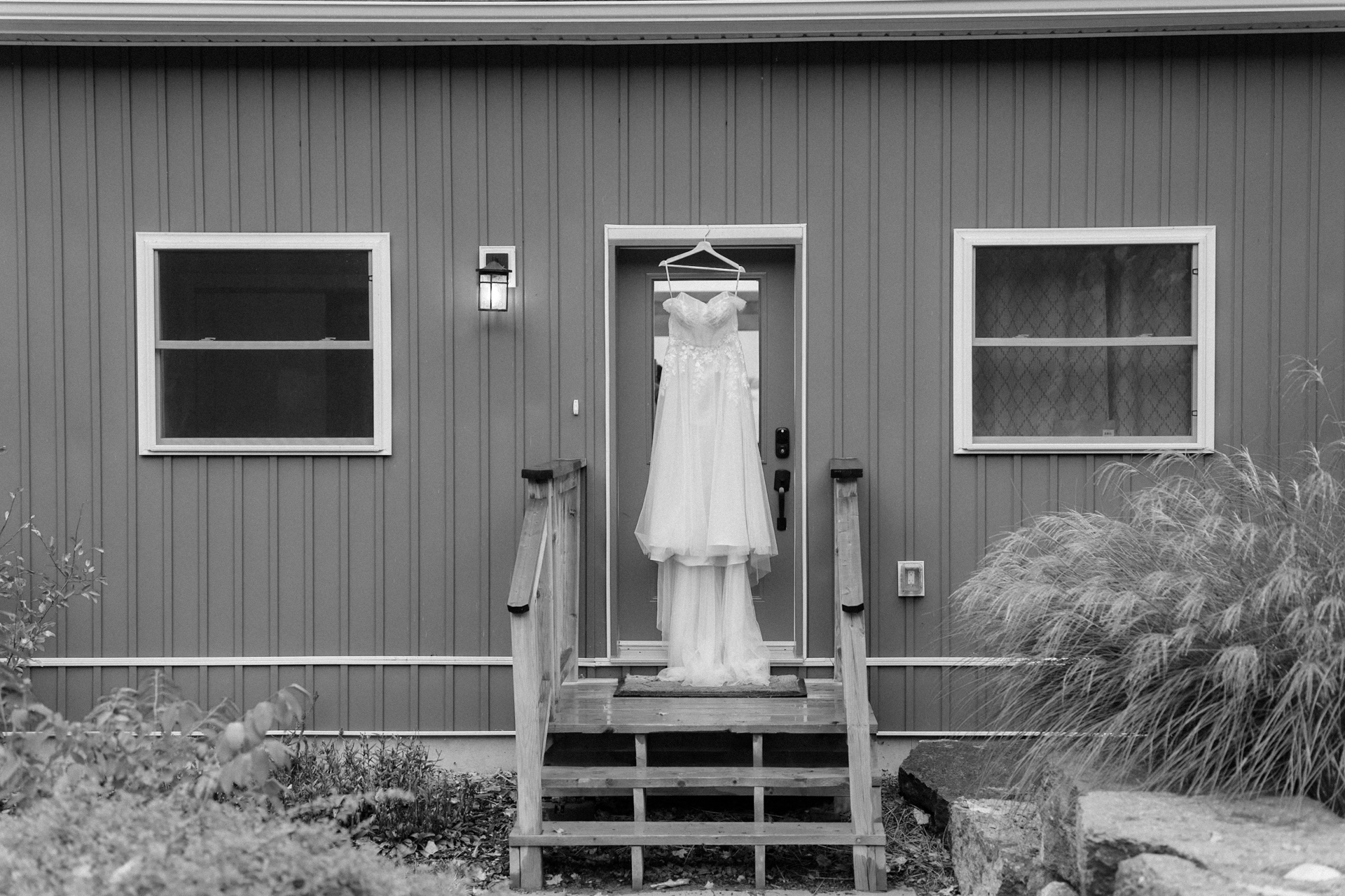 Bride's wedding dress hanging at the front door of Picton Bay Hideaway.