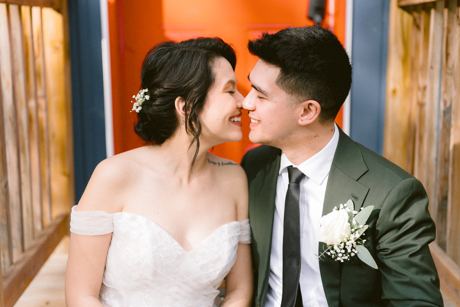 A smiling couple in wedding attire sharing an affectionate moment