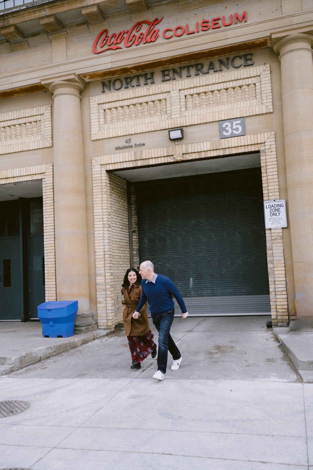 Two people walking briskly across a street in an urban setting