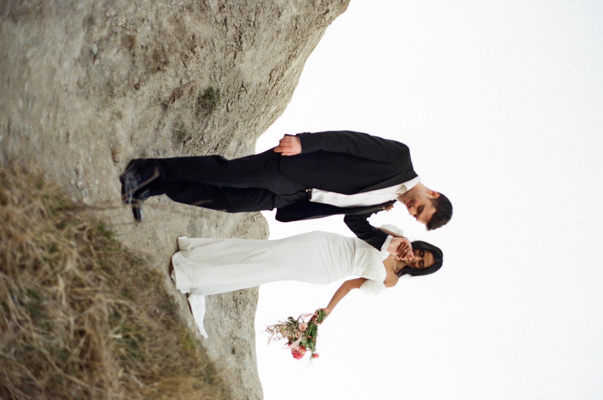 Groom holding the bride walking down the hill for their wedding at Sunrise Hill, Scarborough.