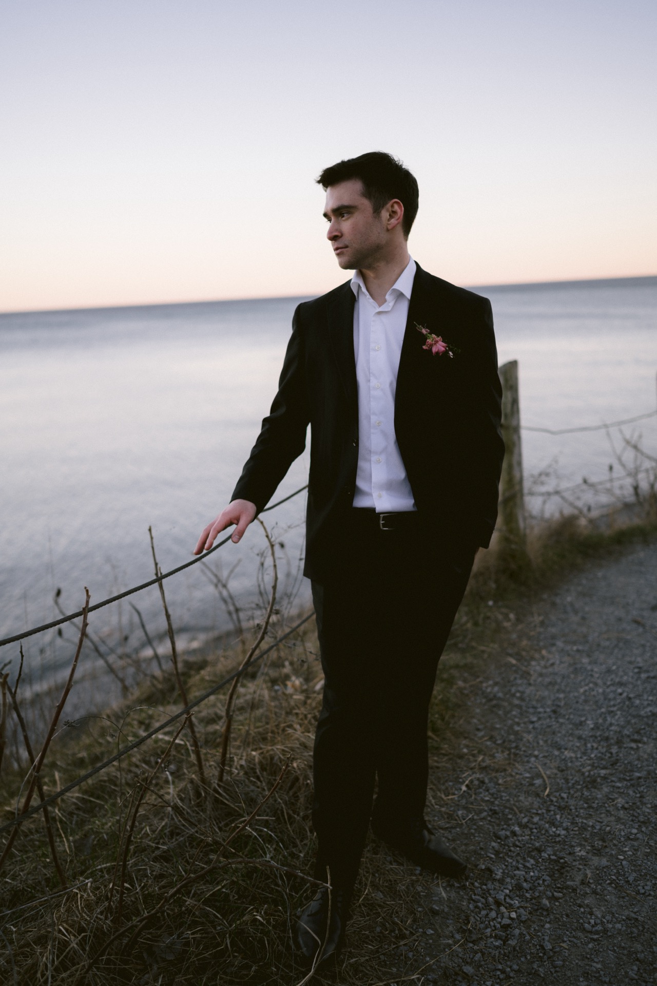 A groom poses for his portrait before the sunset at Sunrise Hill.
