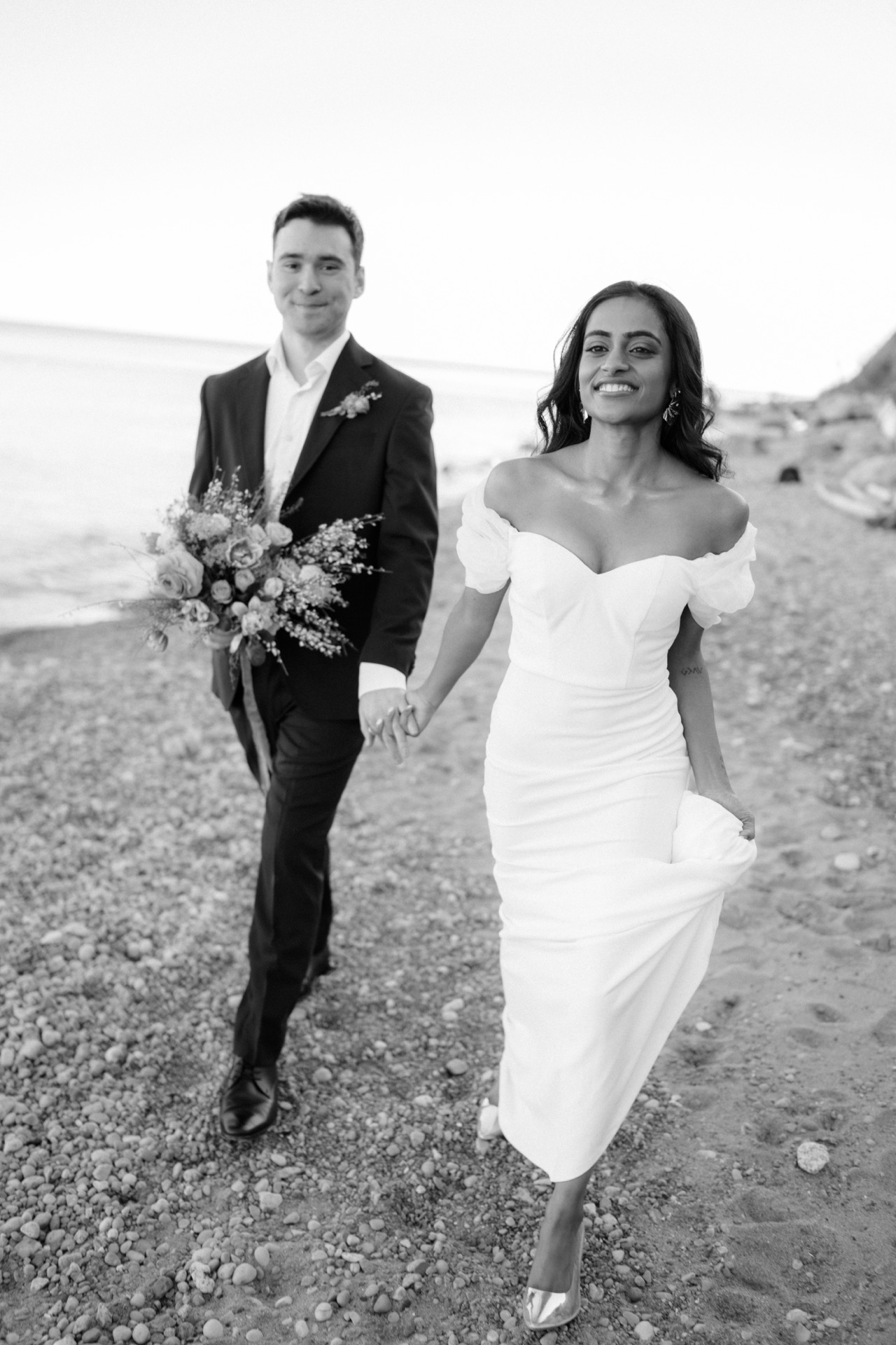 The newlywed hold hands while walking down on a sandy path at Sunrise Hill, Scarborough.
