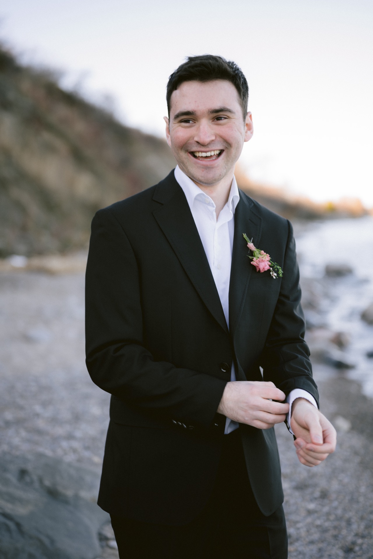 A groom was trying to fix his outfit while taking his portrait.