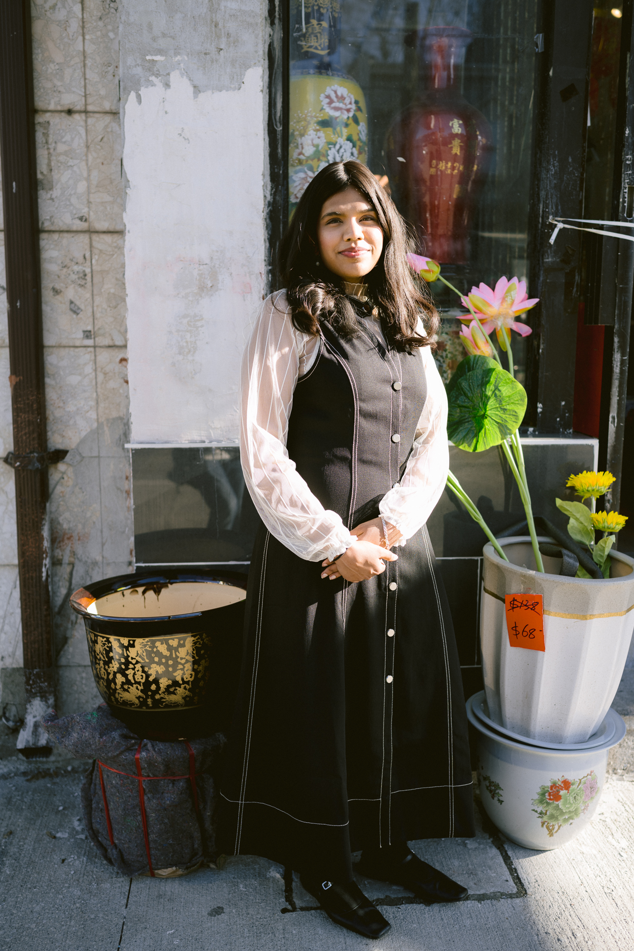 A girl pose for her engagement shoot with Chinese vases surrounded her.