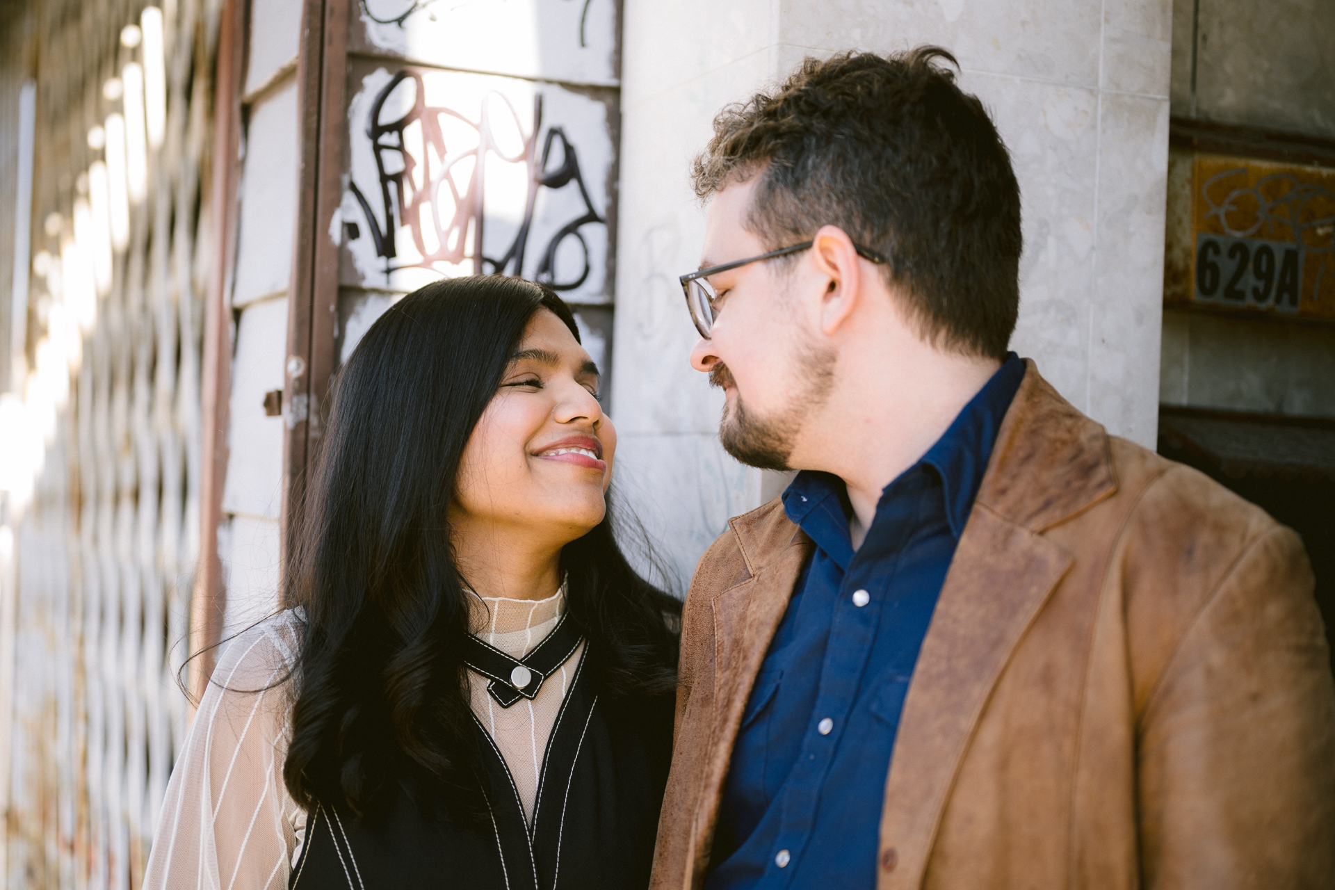 Couple laugh while kissing each other during their engagement photoshoot at Gerrard Street.