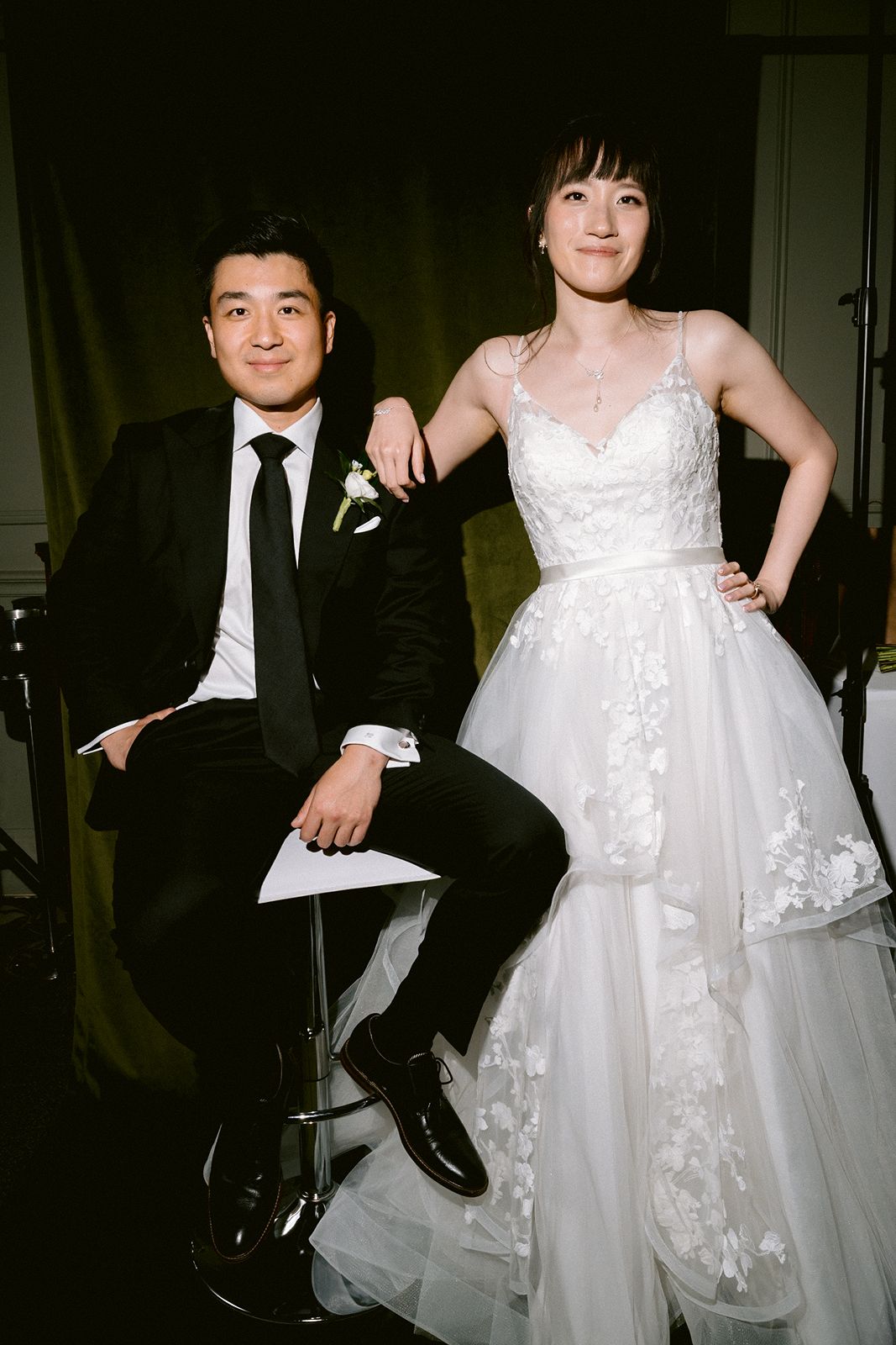 Editorial bridal and groom portrait with a custom green studio backdrop.