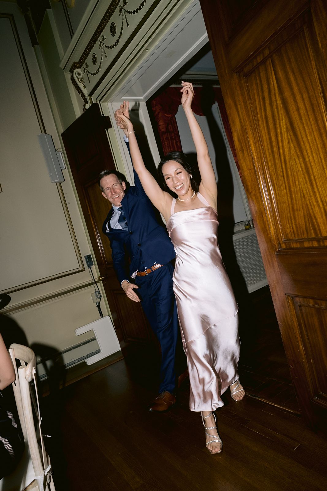 Candid photography of a bride changing outfits for her reception.