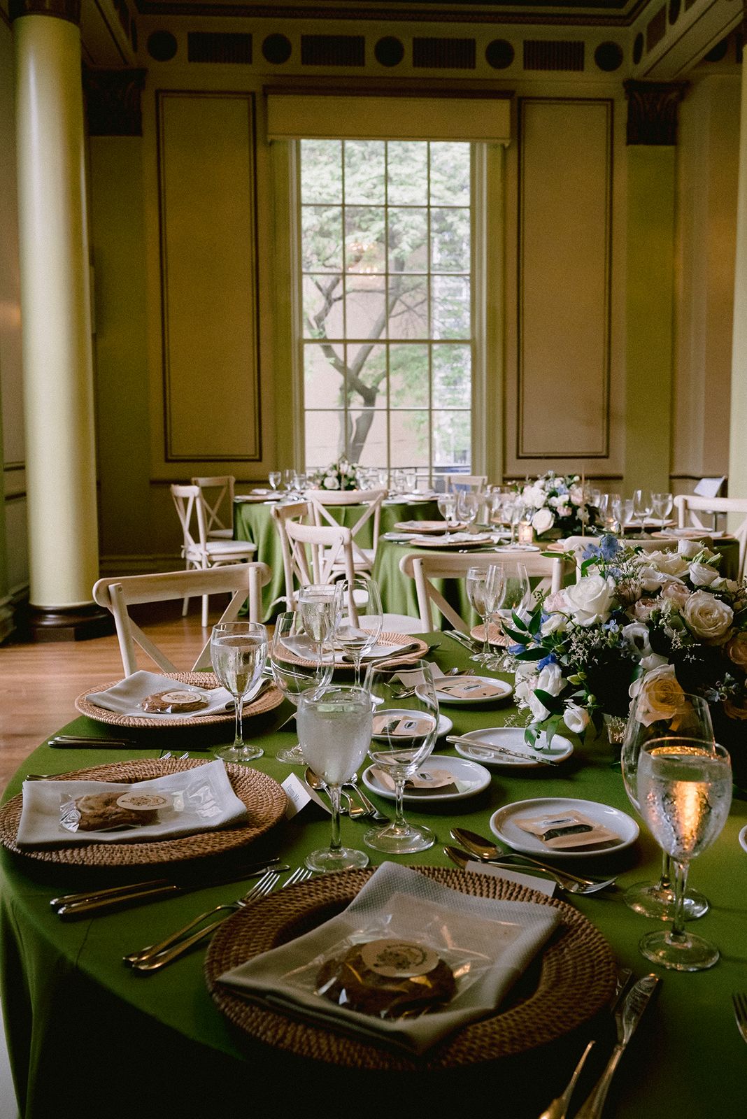 Luxury wedding table setting with green linens and gold accents.
