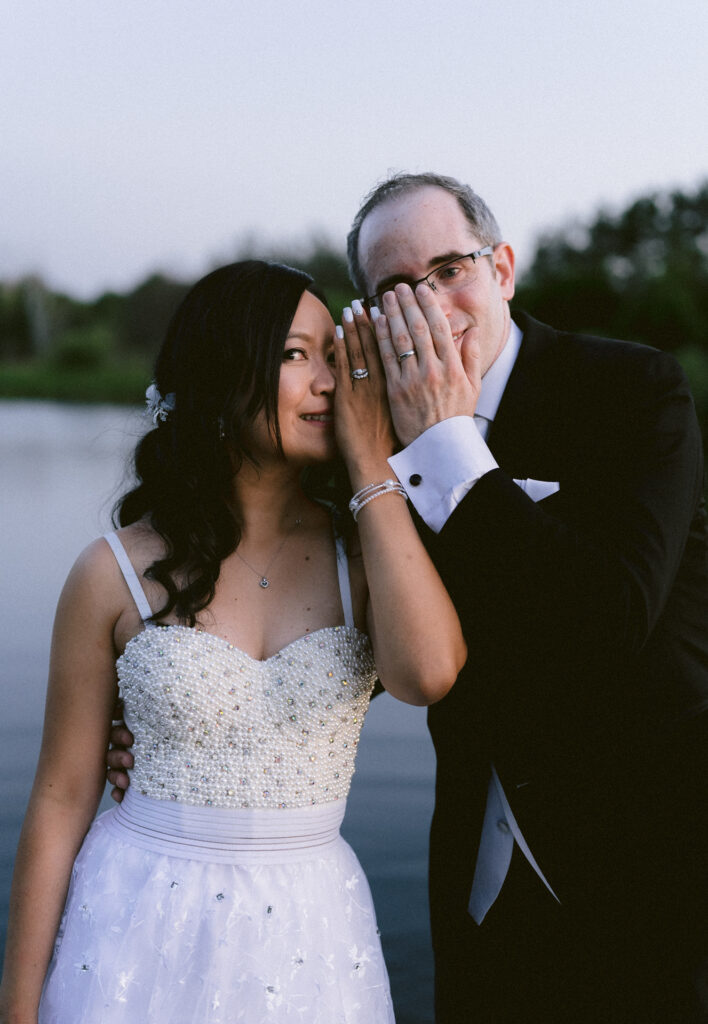 A couple dressed in wedding attire sharing a joyful moment.