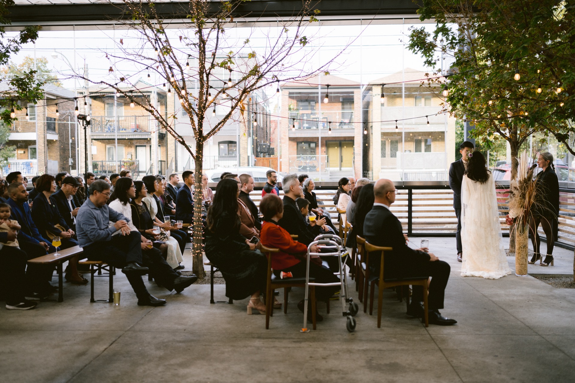 Outdoor micro-wedding ceremony with guests seated looking towards a couple standing at the altar
