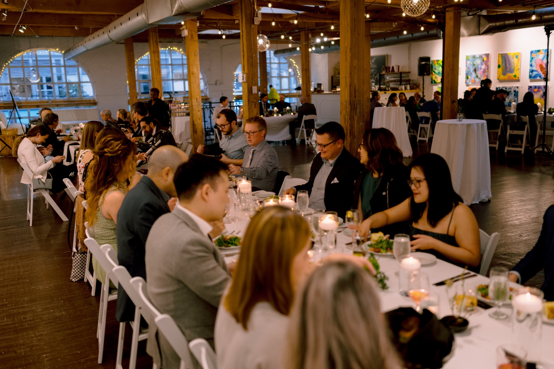 A landscape view of wedding reception with guests enjoying their meals at Twist Gallery.