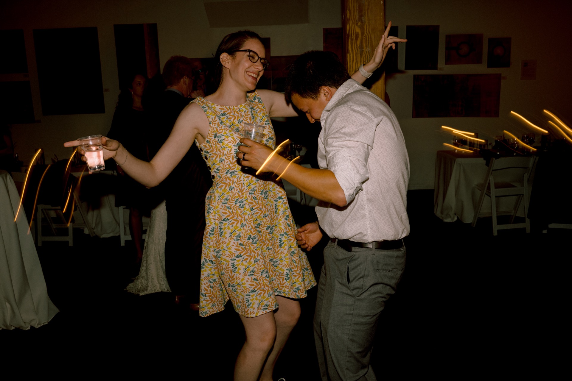 A couple dancing in a dimly lit room with motion blur effects.