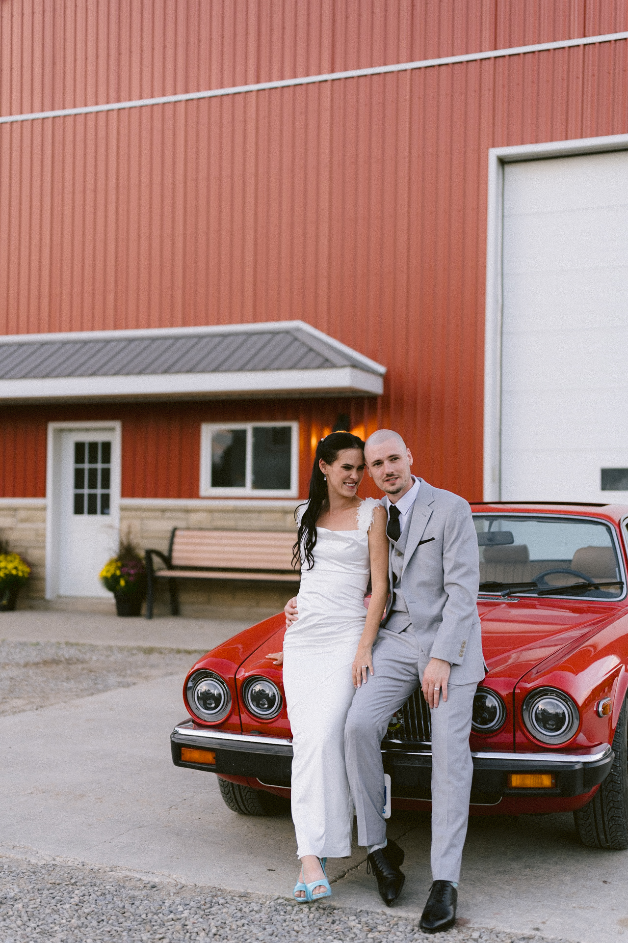 Newlyweds in front of a classic red car