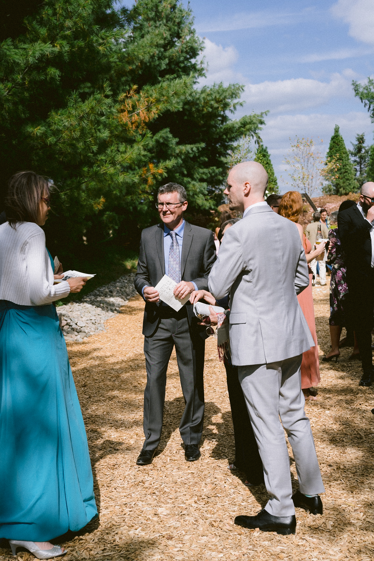 Groom warmly welcoming guests at an outdoor Cambium Farms wedding ceremony.