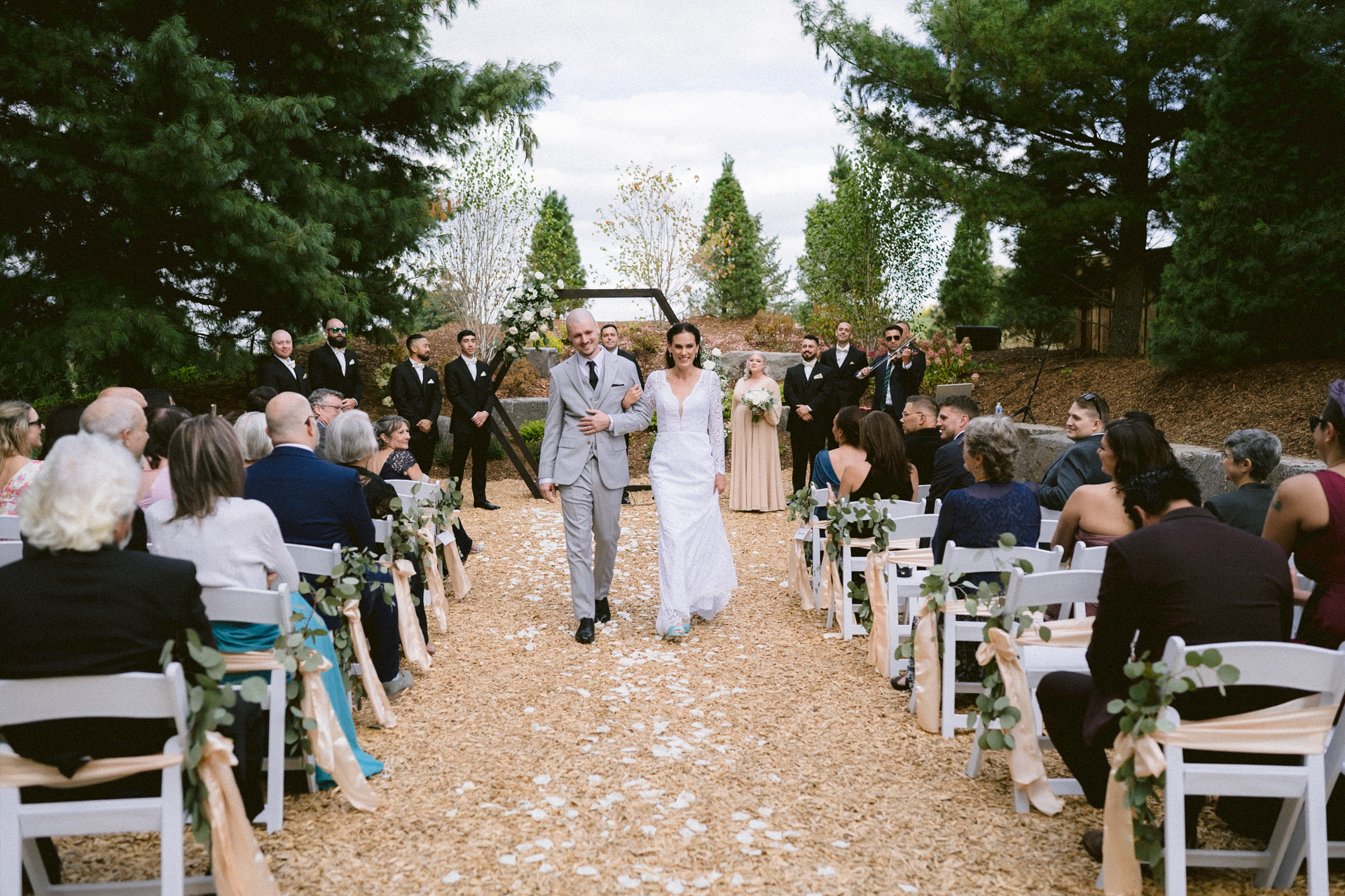 Newlyweds joyfully exiting Cambium Farms ceremony with their guests as witnesses.