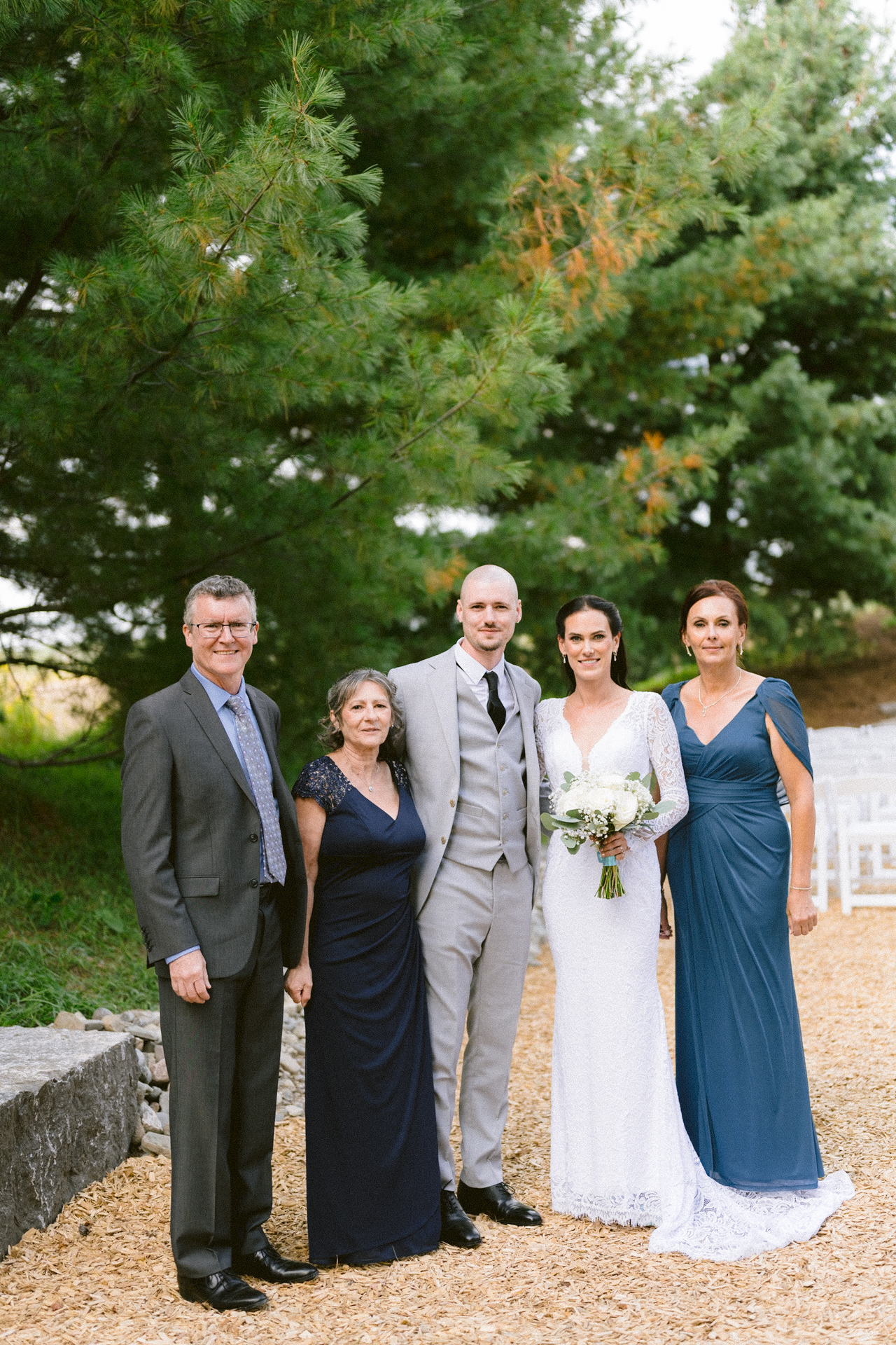 Newlyweds share joyful post-ceremony moment with parents at Cambium Farms wedding.