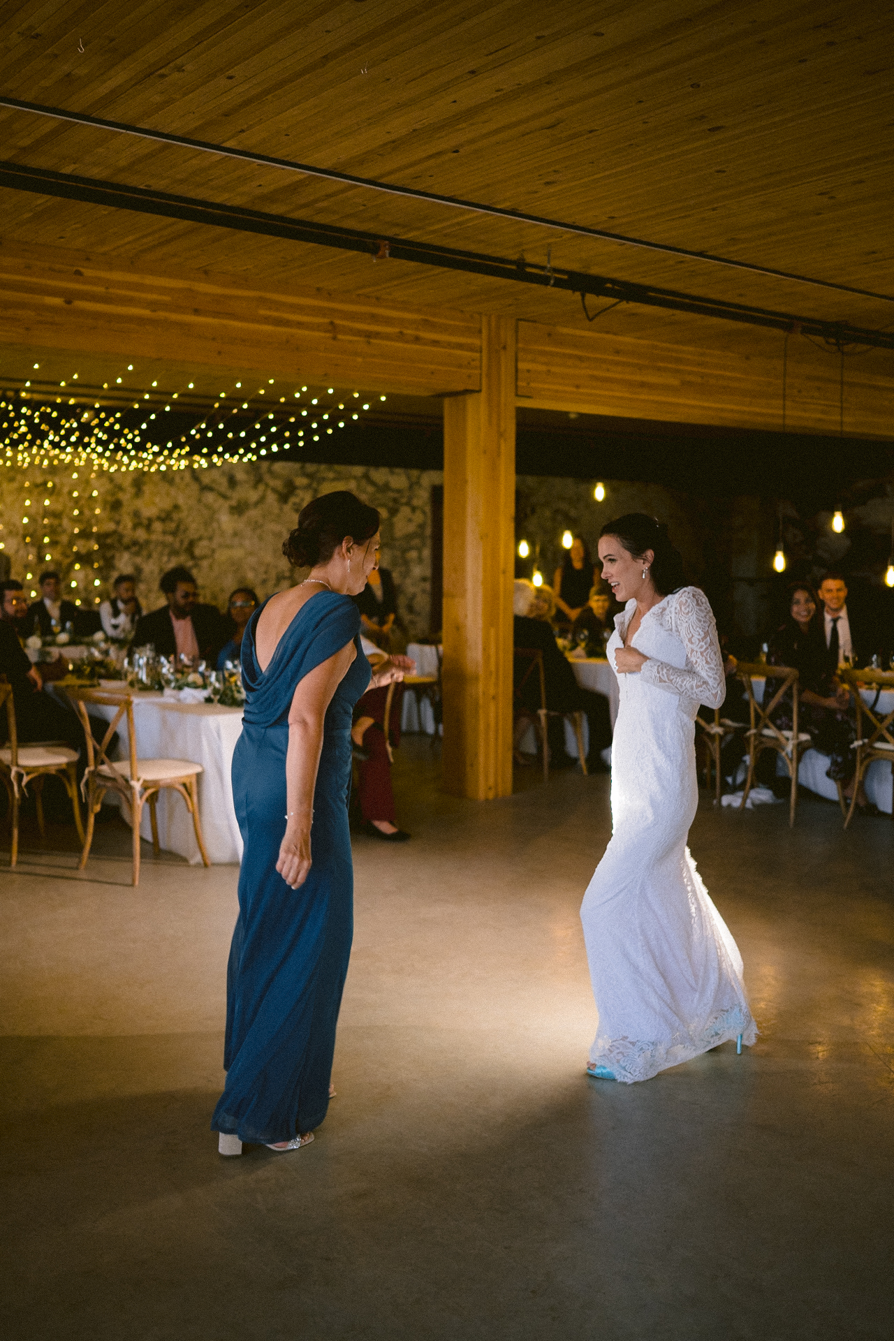 Bride and her mother perform a dance in front of their guests and Toronto wedding photographer.