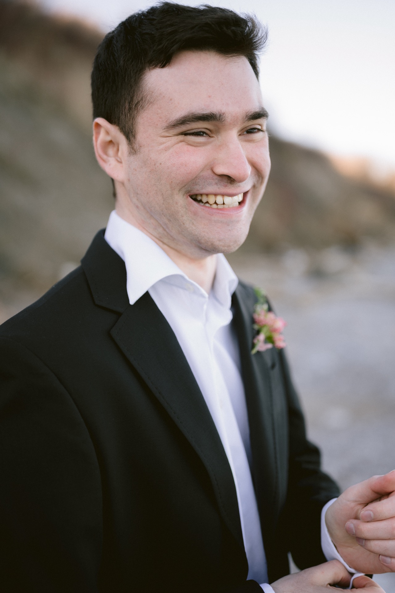 A groom smile happily after a wedding ceremony at Sunrise Hill.