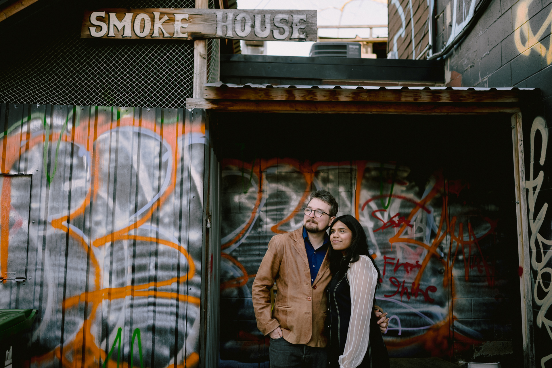 Couple poses in front of an abandon smoke house with full of murals in Gerrard Street.